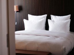 Letto con cuscini e biancheria bianca