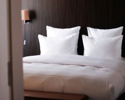 Letto con cuscini e biancheria bianca