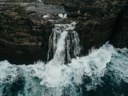 Veduta dall’alto di una cascata sulla costa, accanto al mare